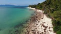 Green jungle and stony beach near sea. Tropical rainforest and rocks near calm blue sea on white sandy shore of Koh Samui paradise Royalty Free Stock Photo