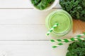 Green kale smoothie in a mason jar, top view, corner border on white wood Royalty Free Stock Photo