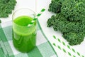 Green kale smoothie with straws on checkered cloth