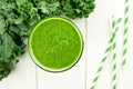 Green kale smoothie on white wood