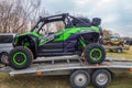 Green Kawasaki Teryx buggyon trailer ready for Mud Racing contest. ATV SSV motobike
