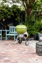 Green kettle barbeque on a stone patio
