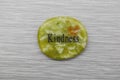 Green Kindness mood stone on grey background Royalty Free Stock Photo