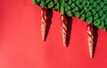 Green knitted handmade Christmas tree with Christmas toys in the form of orange icicles. Beautiful red gradient Christmas