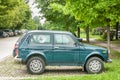 Green Lada Niva 4x4 off road car parked on the street.