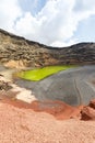 Green lake Charco de Los Clicos Verde near El Golfo portrait format on Lanzarote island on Canary Islands in Spain