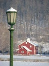 Green lamp post and red barn covered in snow Royalty Free Stock Photo