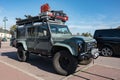 green Land Rover Defender SUV equipped for adventure with the roof rack full of tools and supplies