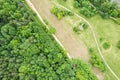 Green landscape with country road in the field near  deciduous forest. aerial top view Royalty Free Stock Photo