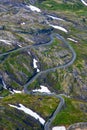 Green landscape with snow patches and a winding road Royalty Free Stock Photo