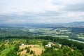 Green landscape with trees, houses and distant hills