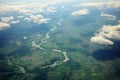 Green landscapes below clouds aerial shot from a plane window