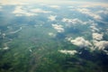 Green landscapes below clouds aerial shot from a plane window