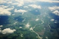 Green landscapes below clouds aerial shot from a plane window