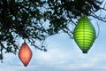 Green Lantern Hanging Under The Tree At Dusk or Dawn with Blur Red Lantern on Background. Royalty Free Stock Photo