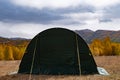 Green large basecamp tent on colorful mountains background