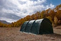 Green large basecamp tent on colorful mountains background