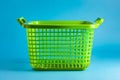 Green laundry basket on blue background. Generative AI Royalty Free Stock Photo