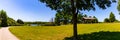 Green lawn by the lake with paved trail and Picnic shelter and seats by the lakeshore