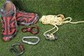 On the green lawn, are mountaineering items, ropes, carabiners and comfortable shoes