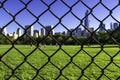 Green lawn of New York Central Park behind a wire fence. Royalty Free Stock Photo