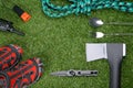 On a green lawn, a traveler`s set, a fork, a spoon, a knife, an ax, a lantern, a rope and comfortable shoes; in the middle there Royalty Free Stock Photo