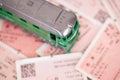 A green leather train model on a background of a pile of train tickets Royalty Free Stock Photo