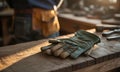 Green Leather Work Gloves on Wooden Surface in Workshop with Natural Lighting Carpentry Equipment and Tools Creates an Authentic Royalty Free Stock Photo