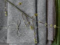 Green leaves laying on the folded gray fabric top view