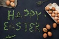 Green leaves lettering Happy Easter with brown eggs Royalty Free Stock Photo