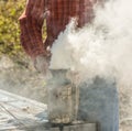 Green leaves on a treebee-keeper with fuming smoker at work place Royalty Free Stock Photo