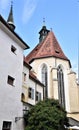 Green leaves, white walls, two church windows and blue sky with small white clouds, in Graz. Royalty Free Stock Photo