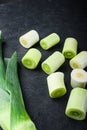 Green leeks sultan  oninon uncooked with herbs ingredients , on textured black background side view with space for text Royalty Free Stock Photo