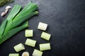 Green leeks sultan  oninon uncooked with herbs ingredients , on textured black background top view with space for text Royalty Free Stock Photo