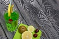 Green lemonade in a glass. Cherry floats in it. Garnished with a slice of lemon and kiwi. With a straw for a cocktail. Nearby on a Royalty Free Stock Photo