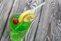 Green lemonade in a glass. Cherry floats in it. Garnished with a slice of lemon. With a straw for a cocktail Royalty Free Stock Photo