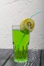 Green lemonade in a glass. Garnished with a slice of lemon and kiwi. With a straw for a cocktail Royalty Free Stock Photo