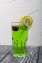 Green lemonade in a glass. Garnished with a slice of lemon and kiwi. With a straw for a cocktail Royalty Free Stock Photo