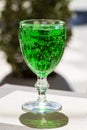 Green lemonade Tarragon in a glass glass on a blurry background, close-up. Green drink from healthy herbs Tarragon