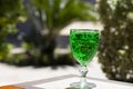 Green lemonade Tarragon in a glass glass on a blurry background, close-up. Green drink from healthy herbs Tarragon
