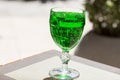 Green lemonade Tarragon in a glass glass on a blurry background, close-up. Green drink from healthy herbs Tarragon