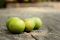 Green lemons on a background of wood