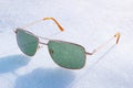 Green lens glasses on bright white snow