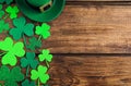 Green leprechaun hat and clover leaves on table, flat lay with space for text. St. Patrick`s Day celebration