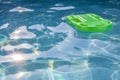 Green lifesaver floating in a swimming pool