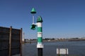 Green light and bouy on a quay along the Nieuwe Waterweg to guide the traffic in the port of Rotterdam