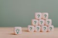 Green light bulb on wooden cube with other blurred question cubes for good idea, best selection, best solution, brain storm