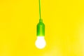 Green Light bulb on yellow background. Free copy space. Concept of new idea, green energy Royalty Free Stock Photo