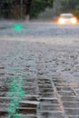 The green light of the traffic light was reflected in large drops of heavy rain at the intersection of the city street