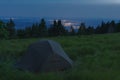 Green lightweight freestanding three-season 2-person tent on mravenecnik hill in grass in the evening Royalty Free Stock Photo